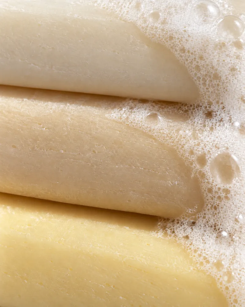 Three bars stacked edge to edge, lather running down their sides.